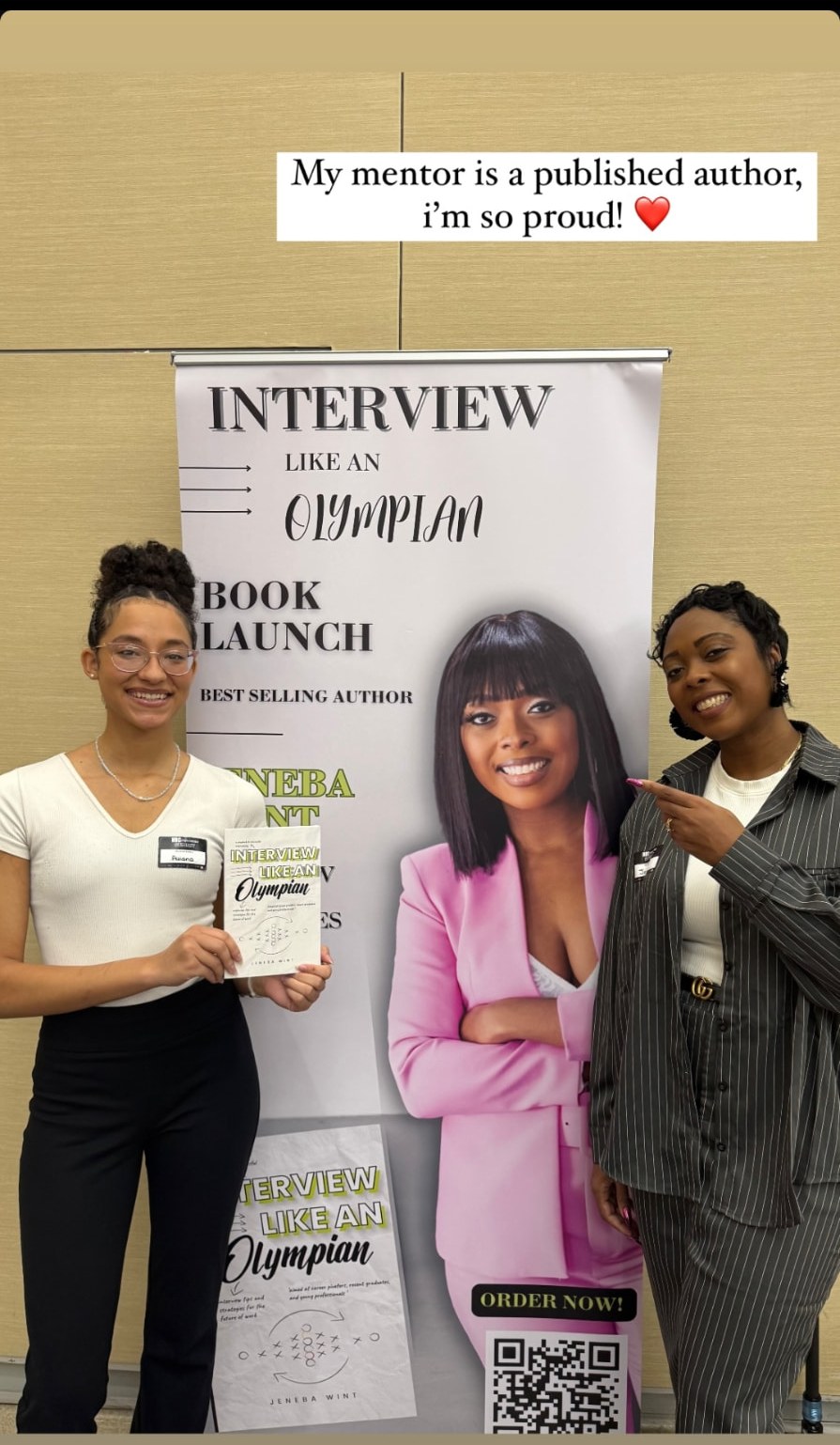 A reader holding a copy of Interview Like an Olympian beside the book launch banner.