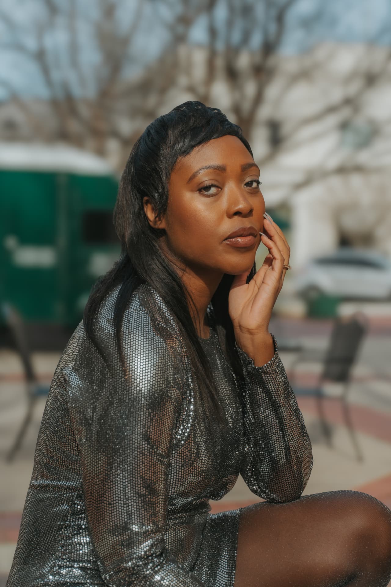 Jeneba Wint wearing a metallic silver outfit in an outdoor urban setting.